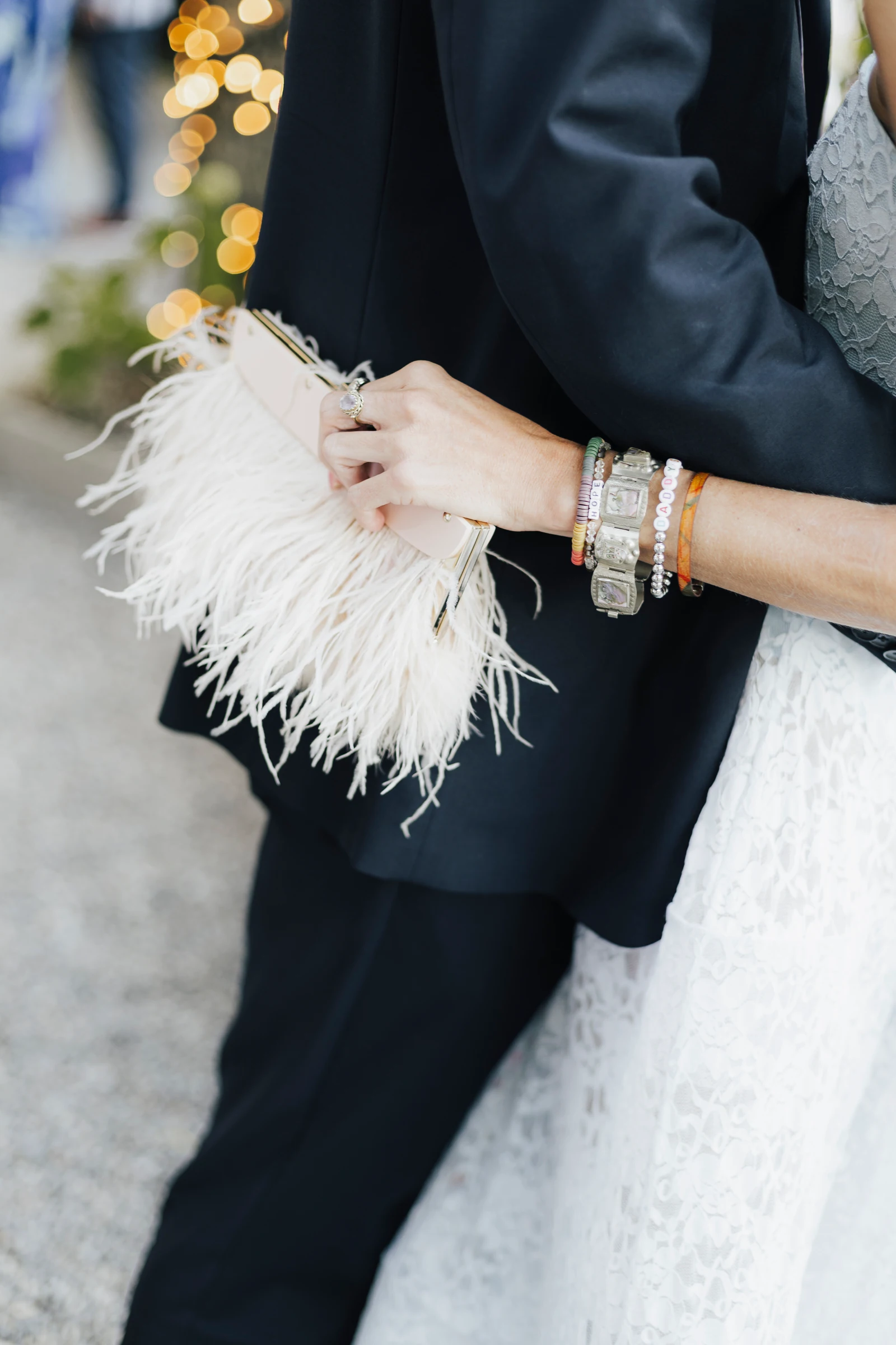 Close-up of a feather clutch and jewellery beside a dark suit at Villa Regina Teodolinda.