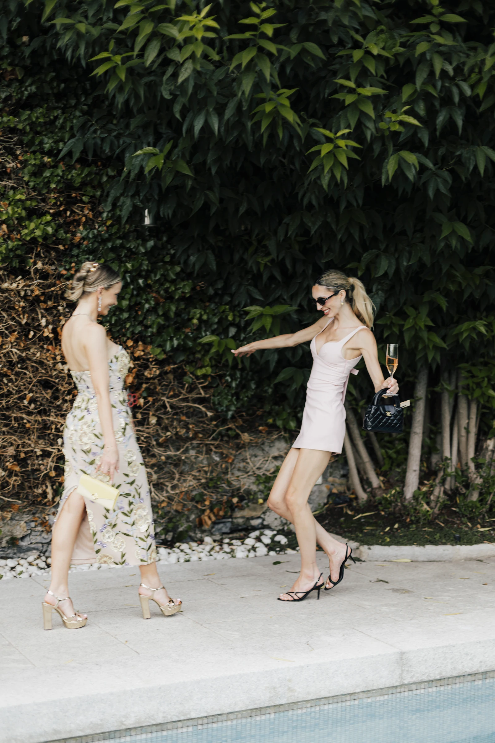 Two guests greeting each other beside the pool at Villa Regina Teodolinda.